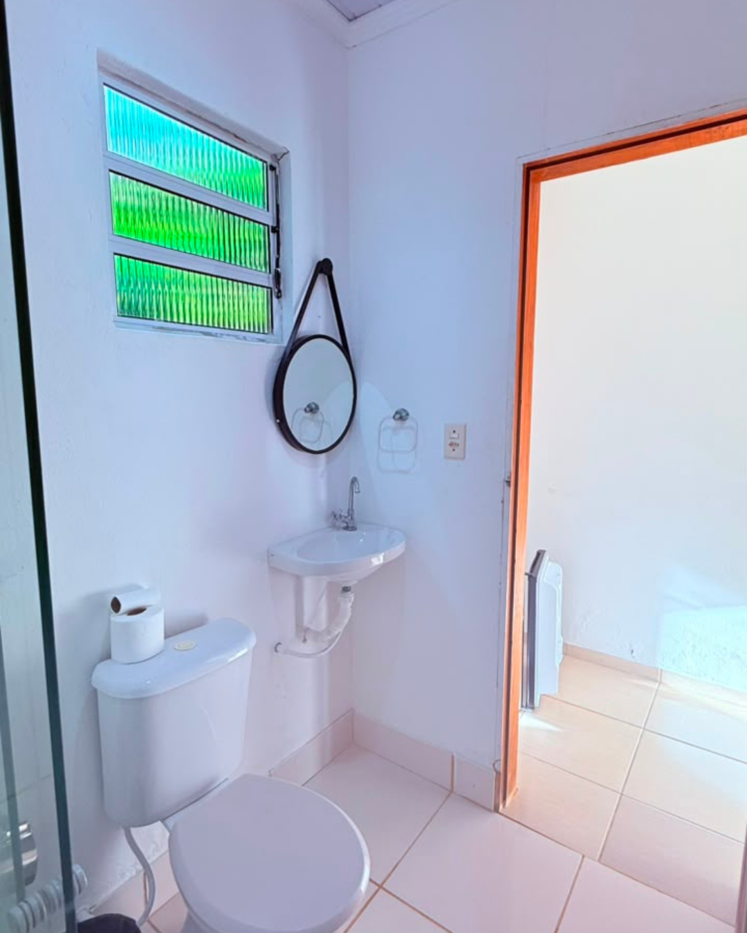 Banheiro claro com detalhes verdes