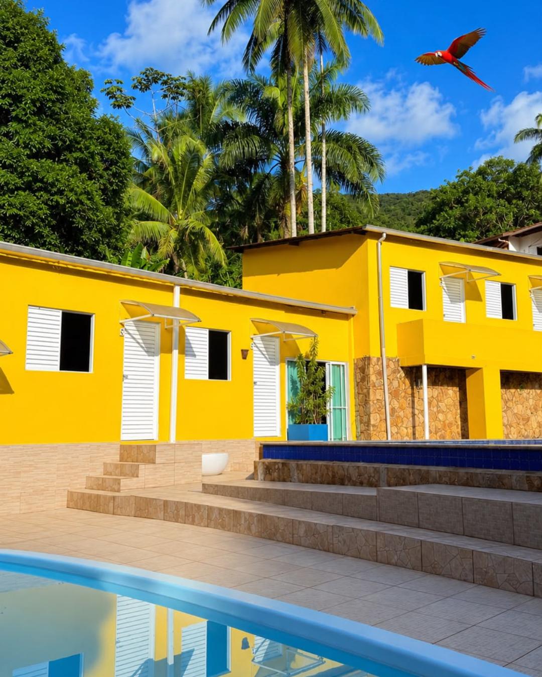 Fachada amarela com piscina e araras